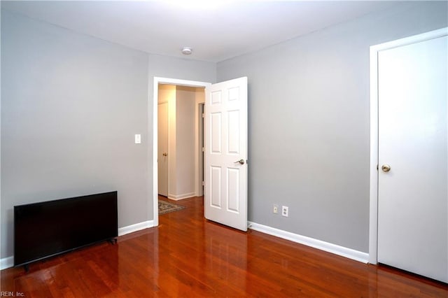 unfurnished bedroom featuring baseboards and wood finished floors