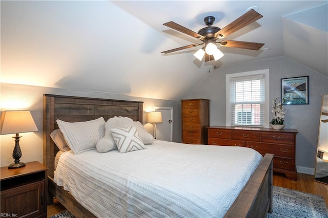 bedroom with lofted ceiling, ceiling fan, baseboards, and wood finished floors