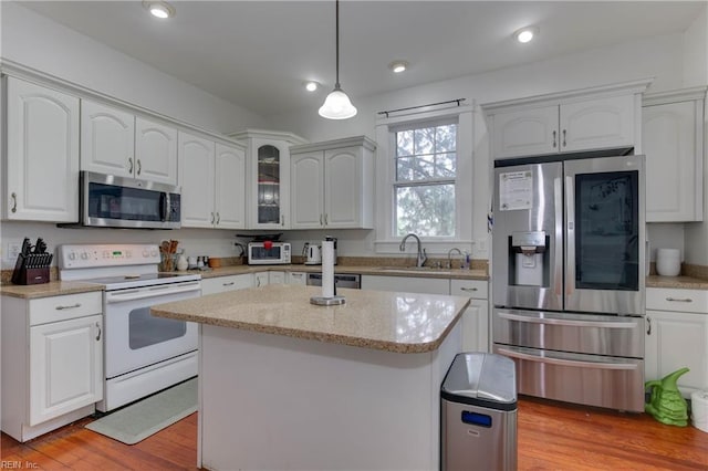 kitchen featuring appliances with stainless steel finishes, white cabinets, and a sink