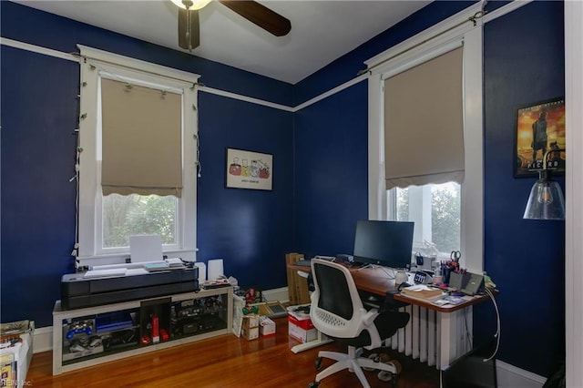 office area with wood finished floors, a ceiling fan, and baseboards