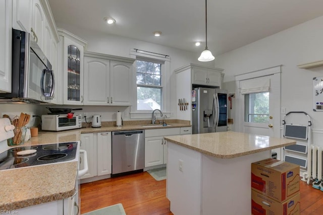 kitchen featuring light wood-style floors, a toaster, appliances with stainless steel finishes, and a sink