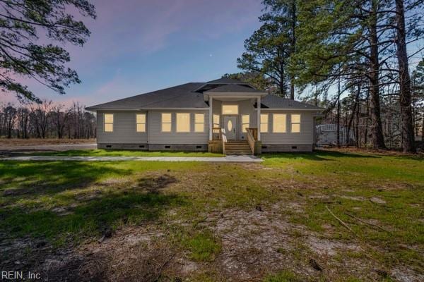 rear view of house with crawl space and a lawn