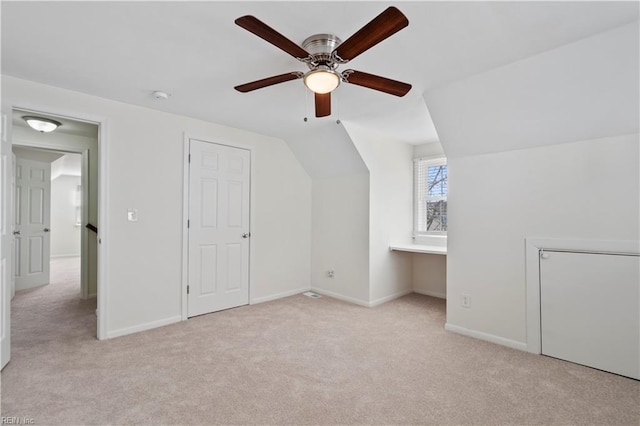 bonus room with lofted ceiling, a ceiling fan, baseboards, and carpet flooring