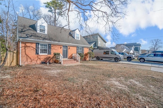 view of front of property with roof with shingles and brick siding