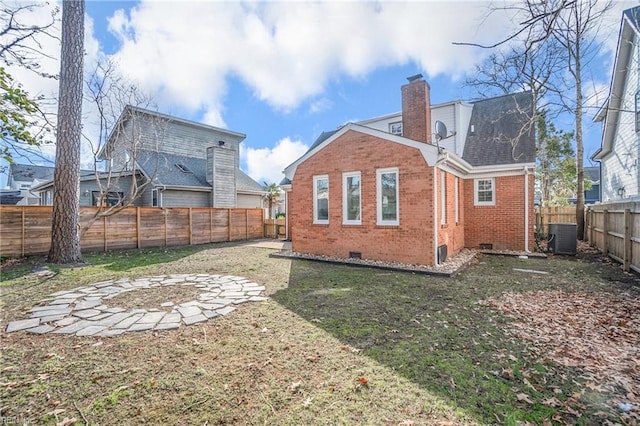 rear view of property featuring a fenced backyard, central air condition unit, brick siding, crawl space, and a chimney