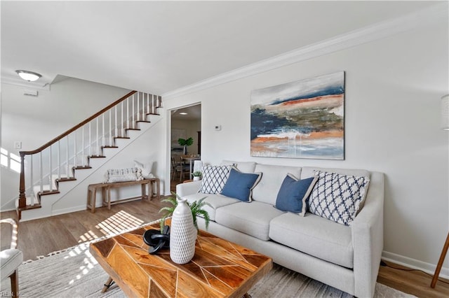 living room featuring baseboards, stairs, ornamental molding, and wood finished floors