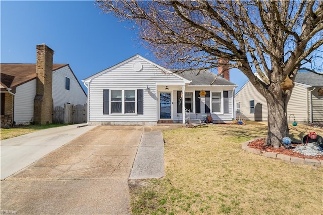 view of front facade with a front yard, fence, and a chimney