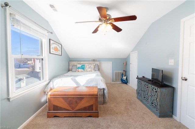 carpeted bedroom with a ceiling fan, vaulted ceiling, baseboards, and visible vents