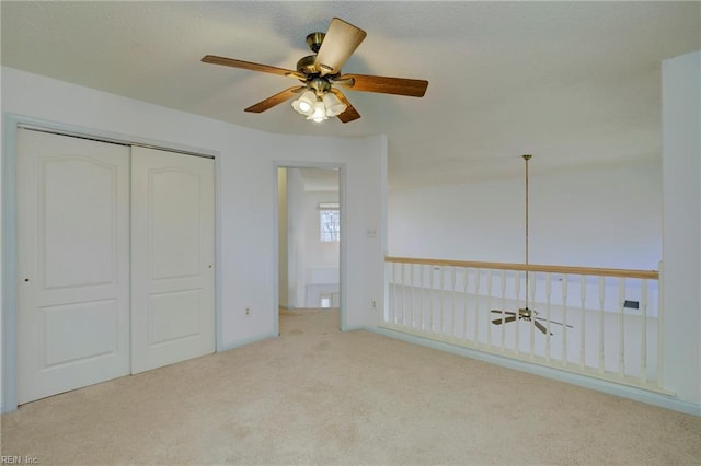 unfurnished bedroom featuring a ceiling fan, carpet, a closet, and a textured ceiling