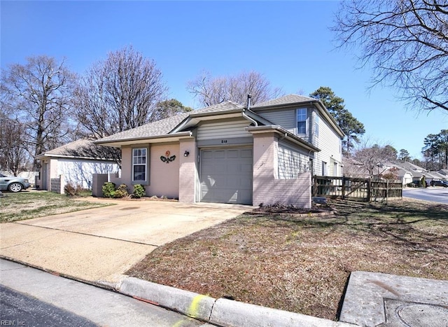 view of front of home featuring an attached garage, cooling unit, concrete driveway, and brick siding