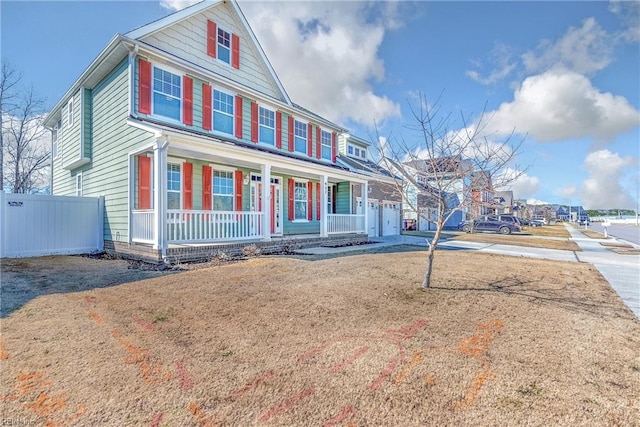 view of front of home featuring driveway, a porch, and fence