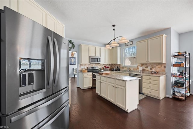 kitchen featuring stainless steel appliances, tasteful backsplash, dark wood-style flooring, and cream cabinets