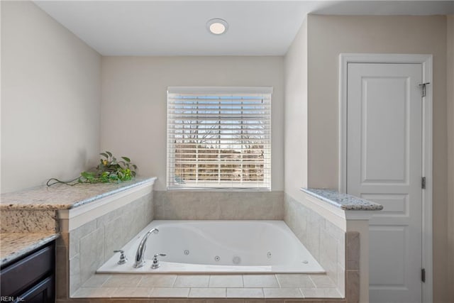 bathroom featuring a tub with jets and vanity