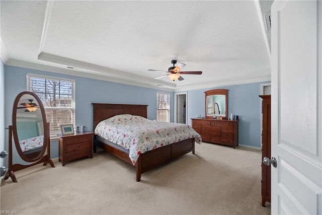 bedroom featuring a tray ceiling, light colored carpet, ornamental molding, ceiling fan, and a textured ceiling