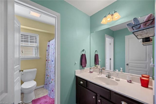 bathroom with baseboards, vanity, toilet, and tile patterned floors