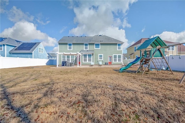 rear view of house with a patio area, a fenced backyard, a playground, and a yard