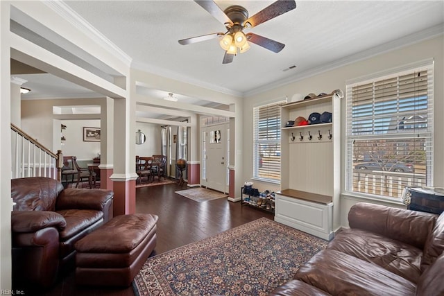 living room with dark wood-style flooring, crown molding, decorative columns, visible vents, and ceiling fan