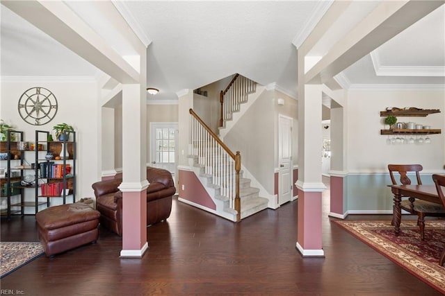 entrance foyer featuring dark wood-type flooring, baseboards, stairs, ornamental molding, and decorative columns