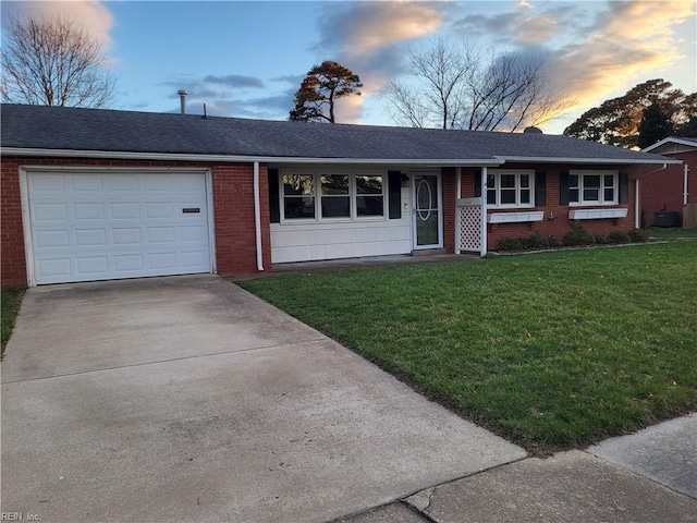 ranch-style home with driveway, brick siding, roof with shingles, an attached garage, and a front yard