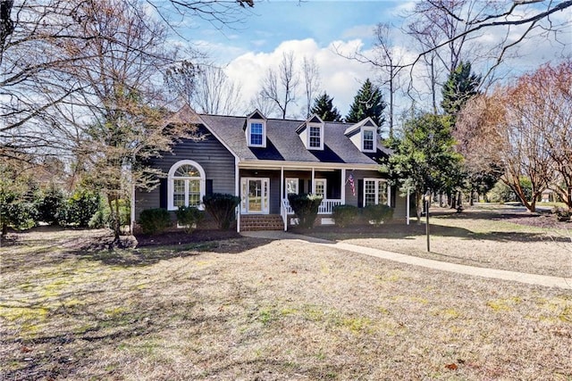 cape cod house featuring a porch and a front lawn