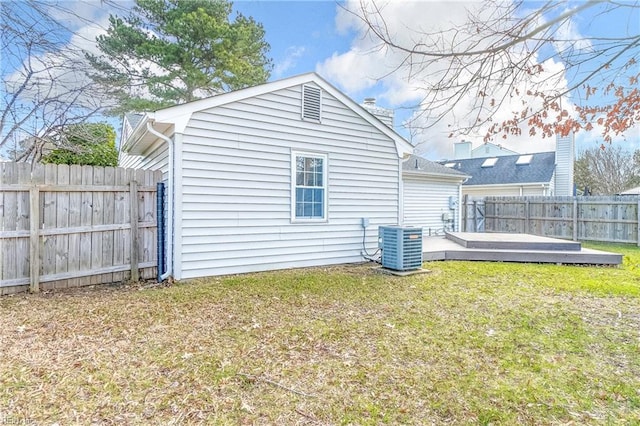 back of house with a fenced backyard, a deck, cooling unit, and a yard