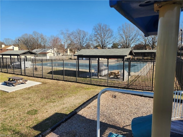 pool featuring a yard, a patio area, and fence