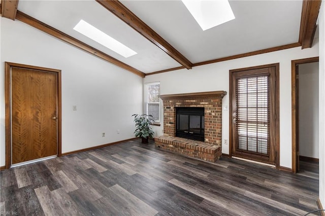 unfurnished living room with wood finished floors, vaulted ceiling with skylight, a fireplace, and baseboards