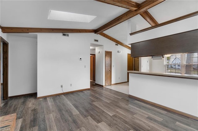 unfurnished living room with visible vents, lofted ceiling with skylight, baseboards, and wood finished floors