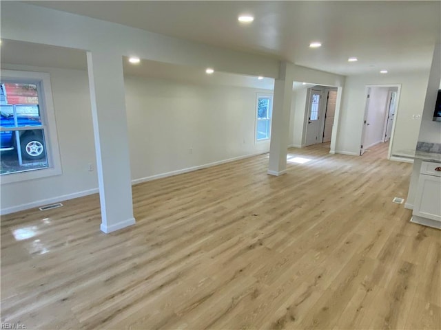 below grade area featuring light wood-style flooring, recessed lighting, visible vents, and baseboards