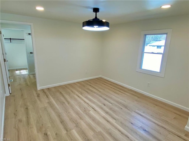 unfurnished room with light wood-style floors, recessed lighting, and baseboards