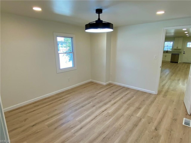 unfurnished dining area featuring baseboards, plenty of natural light, and light wood-style floors