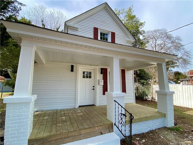 view of front of house featuring covered porch and fence