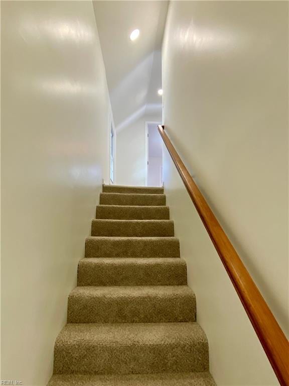 staircase featuring vaulted ceiling and recessed lighting