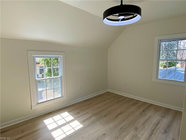 additional living space with a ceiling fan, baseboards, vaulted ceiling, and light wood finished floors