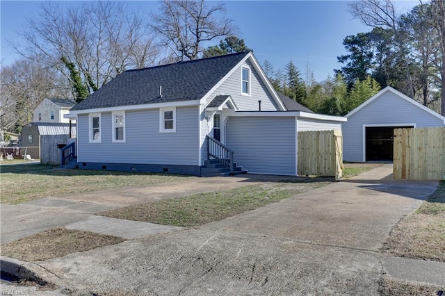 exterior space with a garage, entry steps, roof with shingles, crawl space, and fence