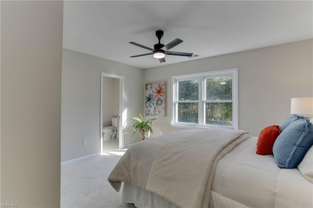 carpeted bedroom with ensuite bath, ceiling fan, visible vents, and baseboards