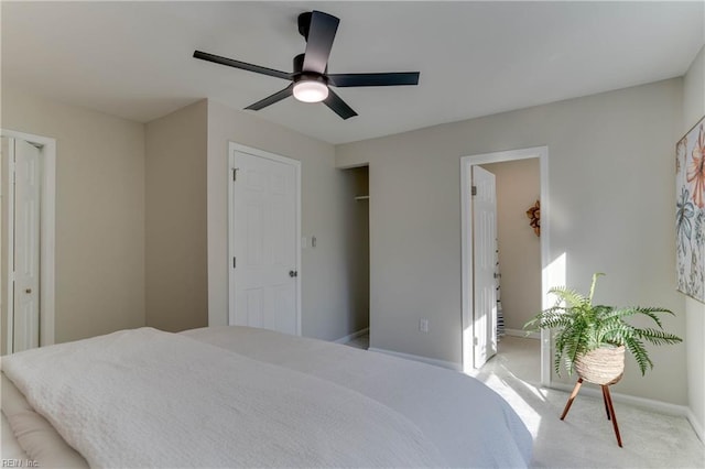 bedroom featuring a ceiling fan, light colored carpet, and baseboards