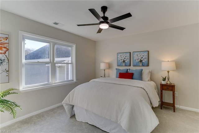 bedroom with light colored carpet, ceiling fan, visible vents, and baseboards