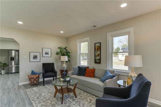 living area featuring baseboards, wood finished floors, and recessed lighting