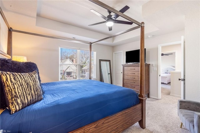 bedroom featuring ceiling fan, carpet floors, a tray ceiling, and baseboards