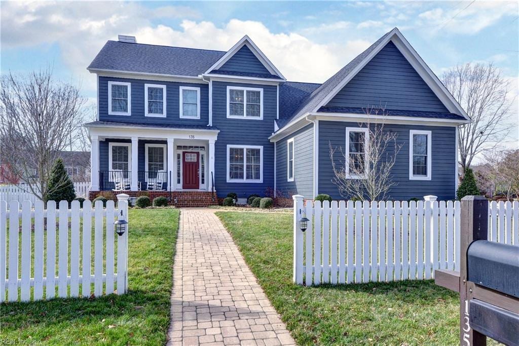 view of front of property featuring covered porch, a chimney, a front yard, and fence