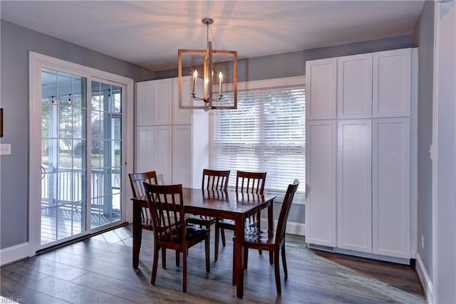 dining area with a chandelier, a healthy amount of sunlight, dark wood-type flooring, and baseboards