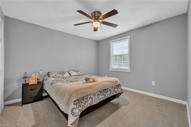 carpeted bedroom with ceiling fan and baseboards