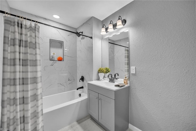 full bath featuring a textured wall, vanity, and shower / tub combo with curtain