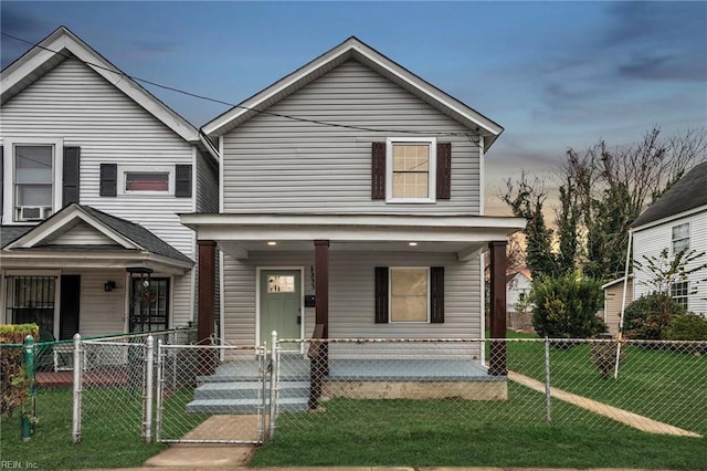 view of front facade featuring a porch, a front yard, a gate, and a fenced front yard