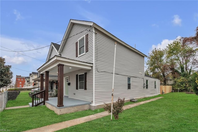 view of side of home with a patio, a lawn, and a fenced backyard