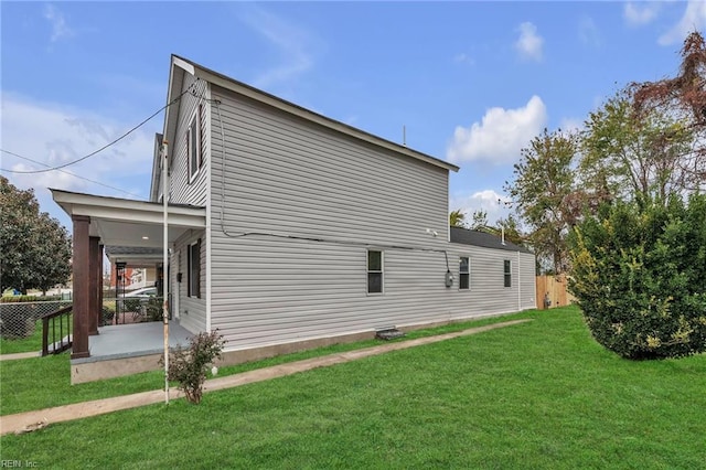 view of property exterior with a patio, a lawn, and fence