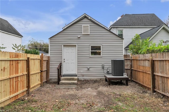 back of property featuring entry steps, a fenced backyard, and central AC unit