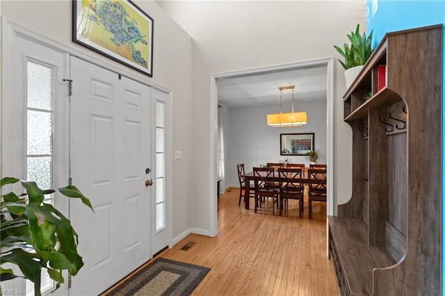 entryway with visible vents, light wood-style flooring, and baseboards