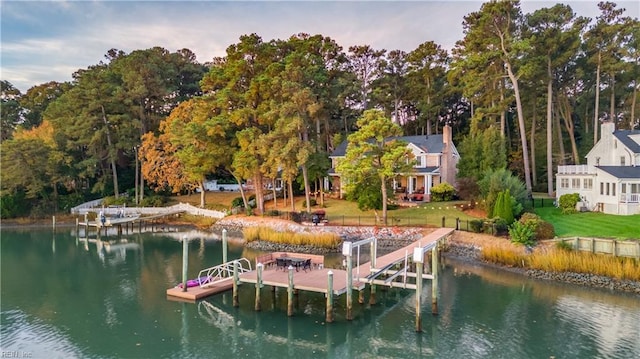 view of dock featuring boat lift, a lawn, and a water view